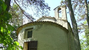 A rustic, single-story building with a small bell tower, surrounded by trees and greenery. - B&B Il Prato (Predappio)