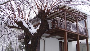 A two-story building with a balcony, surrounded by snow-covered trees. - B&B Il Prato (Predappio)