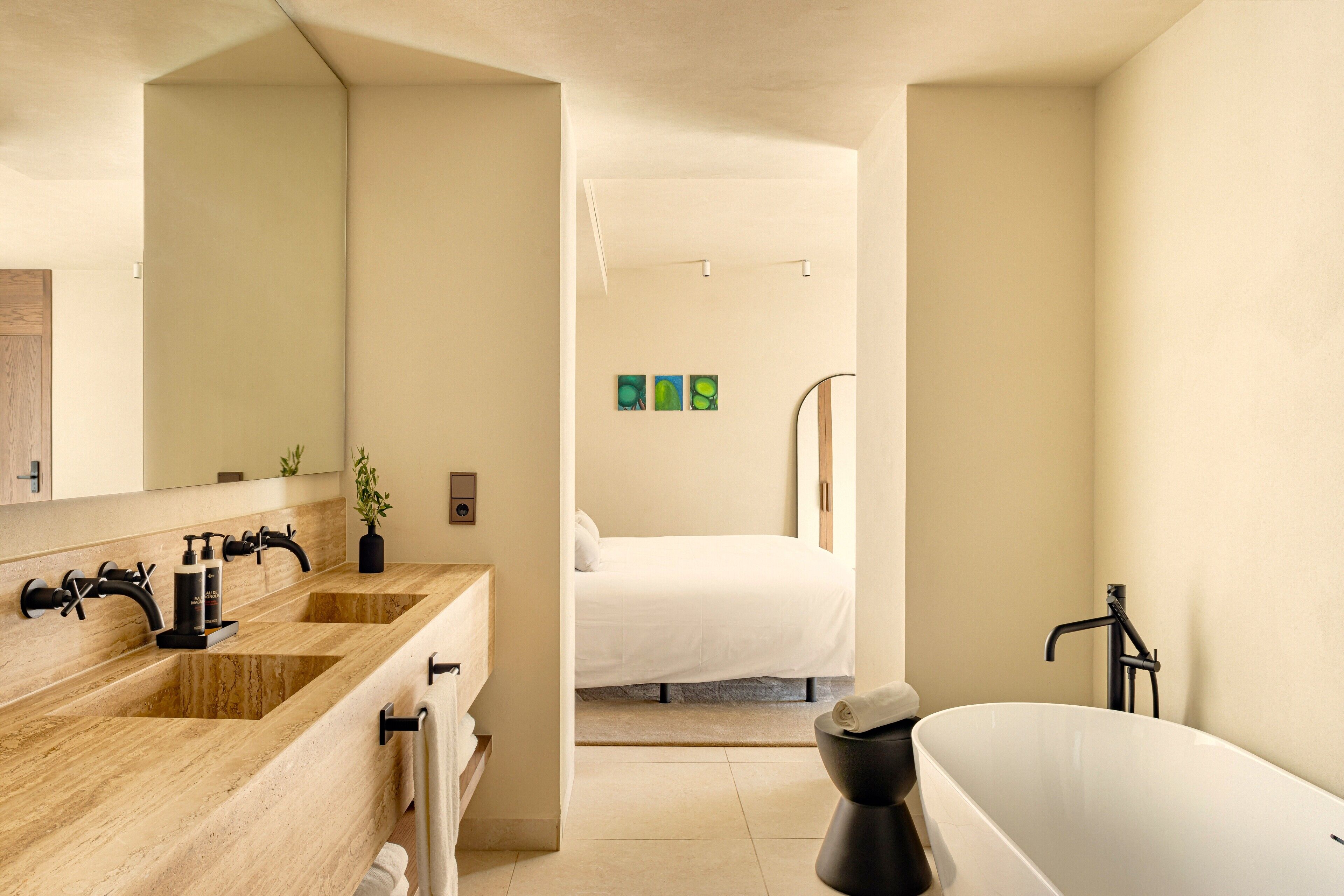 A modern bathroom with a wooden vanity, a freestanding bathtub, and a large mirror.
