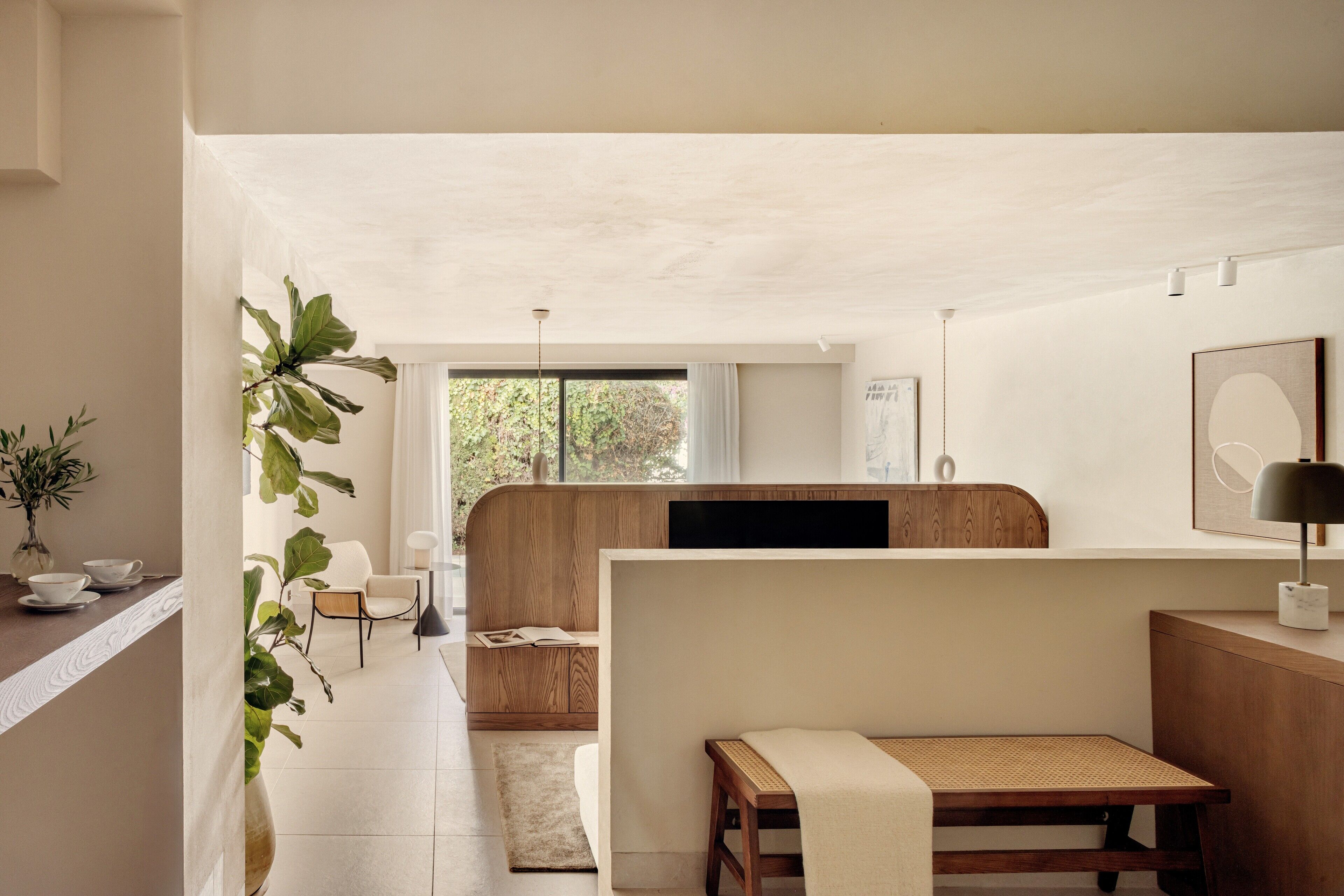 Una sala de estar moderna y minimalista con un sofá, una mesa de centro y un comedor con una mesa y sillas.