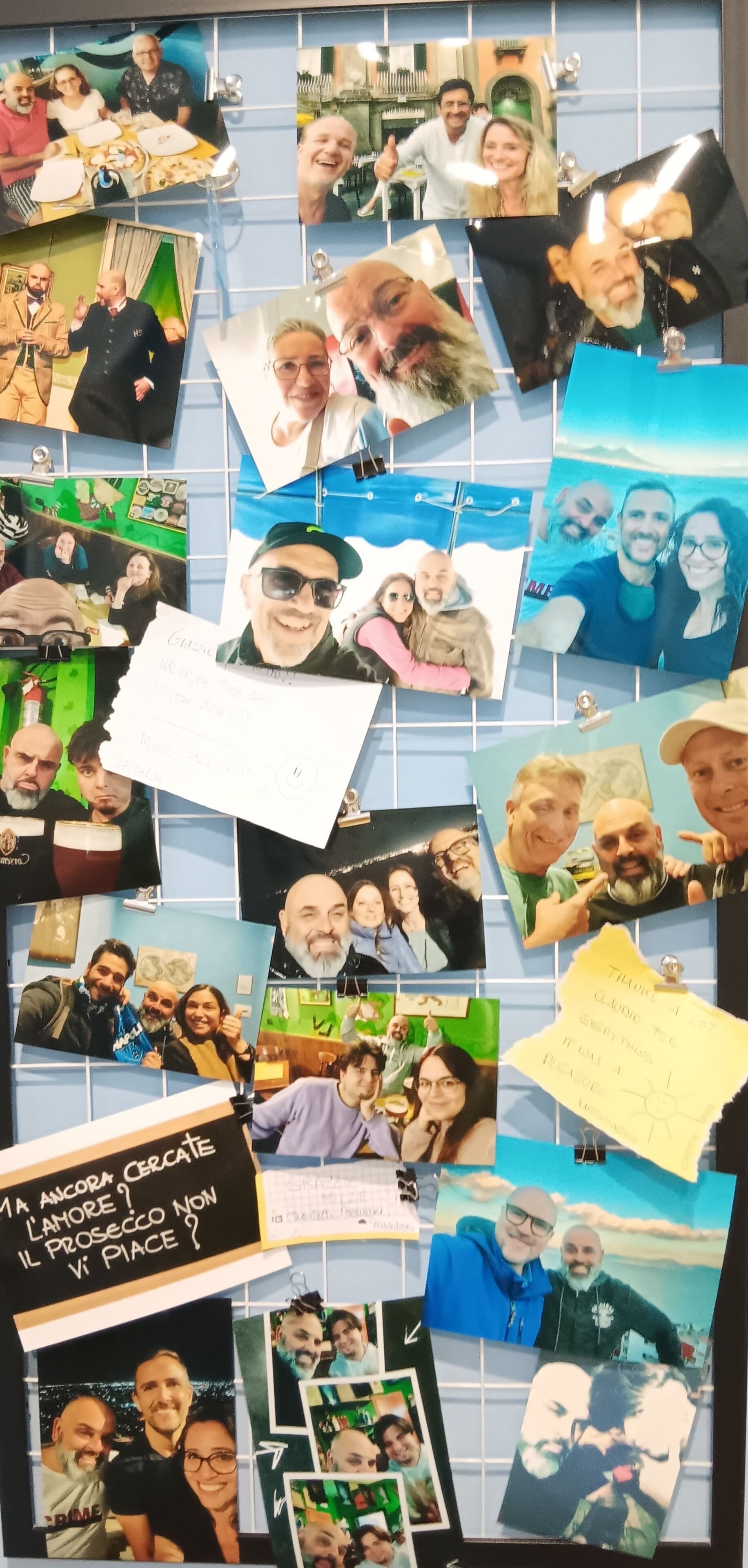 Un muro ricoperto di fotografie e appunti, alcuni con scritte e altri con immagini di persone.