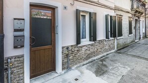 Una hilera de casas adosadas con puerta de madera, número 18, y un buzón pequeño en la planta baja.