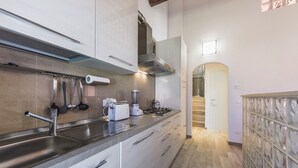 Una cocina moderna con electrodomésticos de acero inoxidable, horno empotrado y un amplio ventanal.