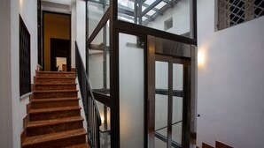 A staircase with marble steps leading to a glass door. - Quattro Canti Charming Flat (Palermo)