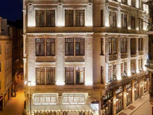 A multi-story building with a classical architectural style, featuring large windows and a prominent entrance with a canopy.