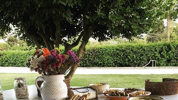 An outdoor dining setup with various food items and a decorative vase.