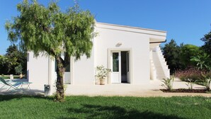 A modern house with a white exterior, a small front porch, and a staircase leading to the entrance.
