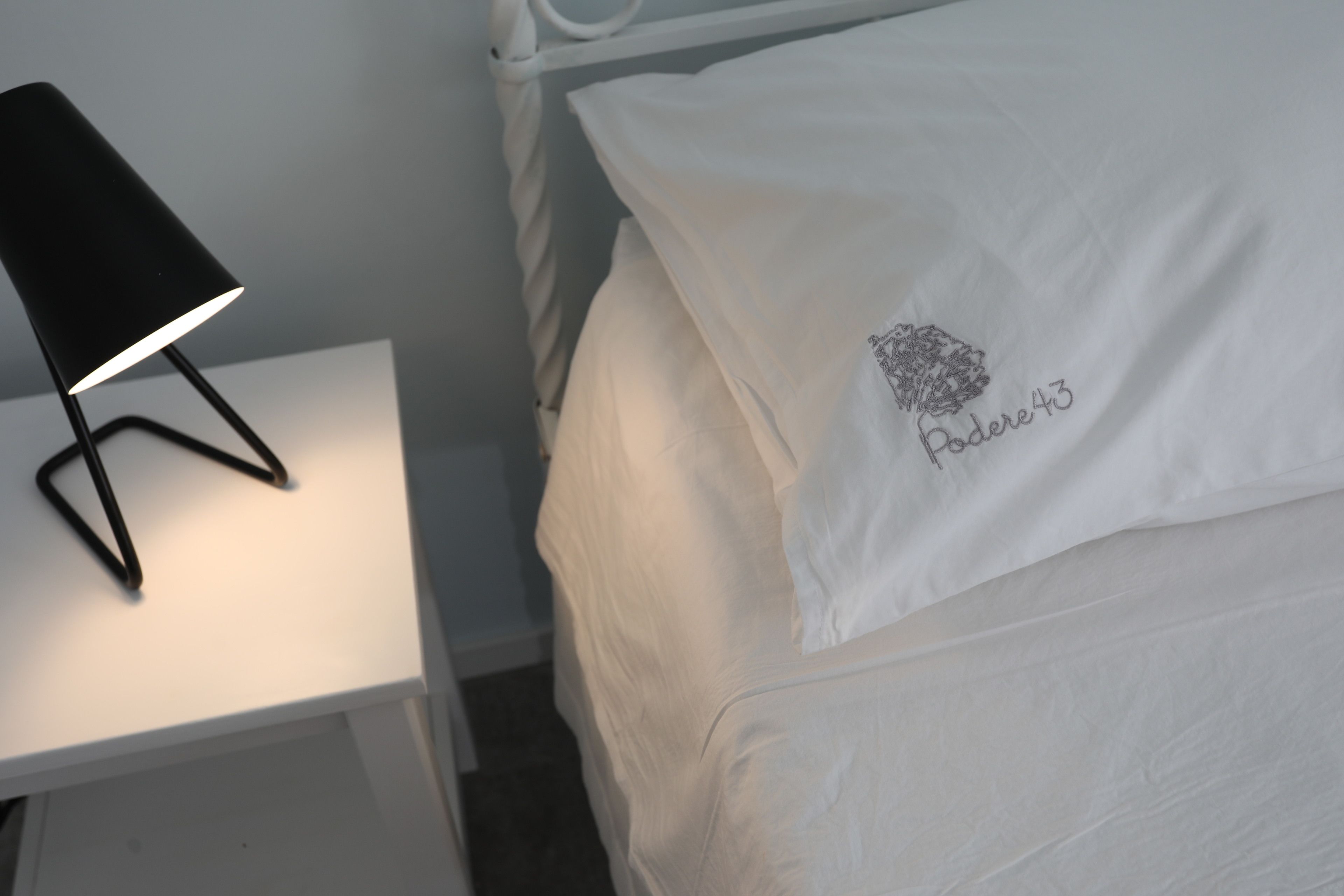 Ein ordentlich bezogenes Bett mit einem Kissen, bestickt mit "Paddere43".