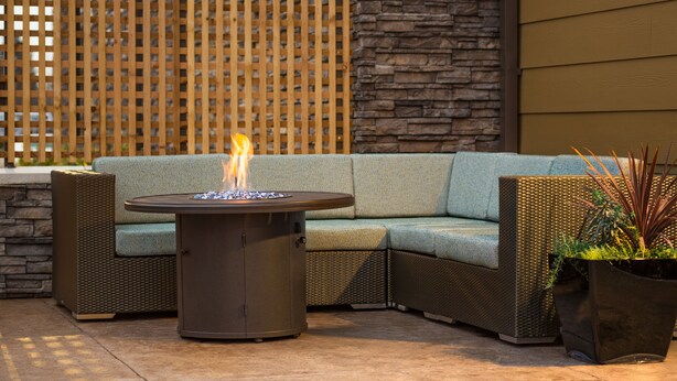 An outdoor seating area with a round table, a sofa, and a potted plant. - Best Western Premier Hotel at Fisher's Landing (Vancouver)