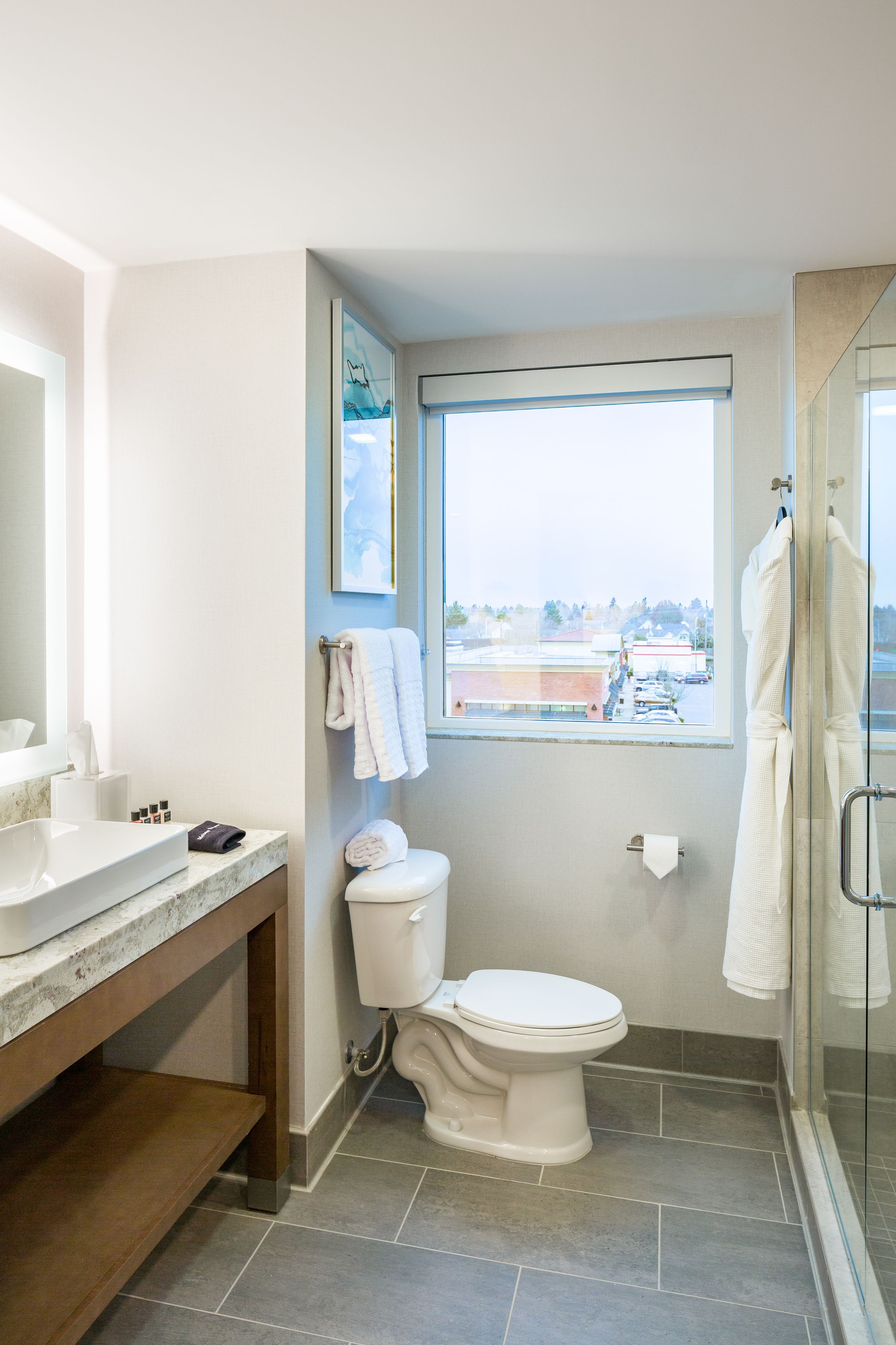 A modern bathroom with a toilet, sink, and shower.