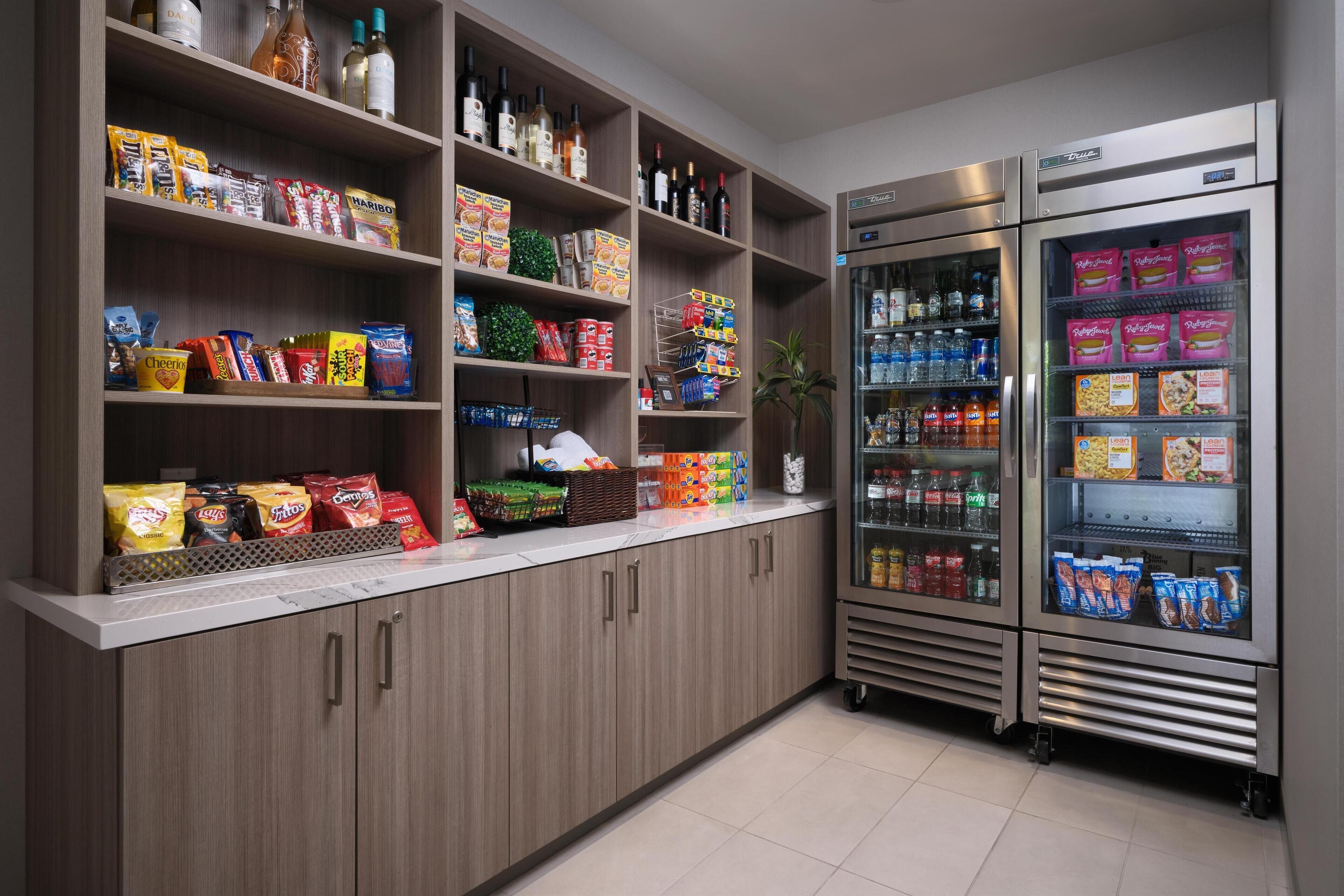 A well-stocked snack and beverage area with shelves of snacks, bottled drinks, and refrigerated sections.