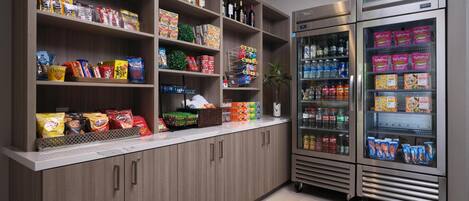 A well-stocked snack and beverage area with shelves of snacks, bottled drinks, and refrigerated sections.