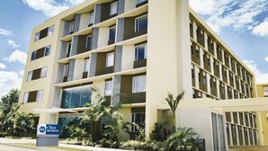 A multi-story hotel with a modern design, featuring balconies and large windows.