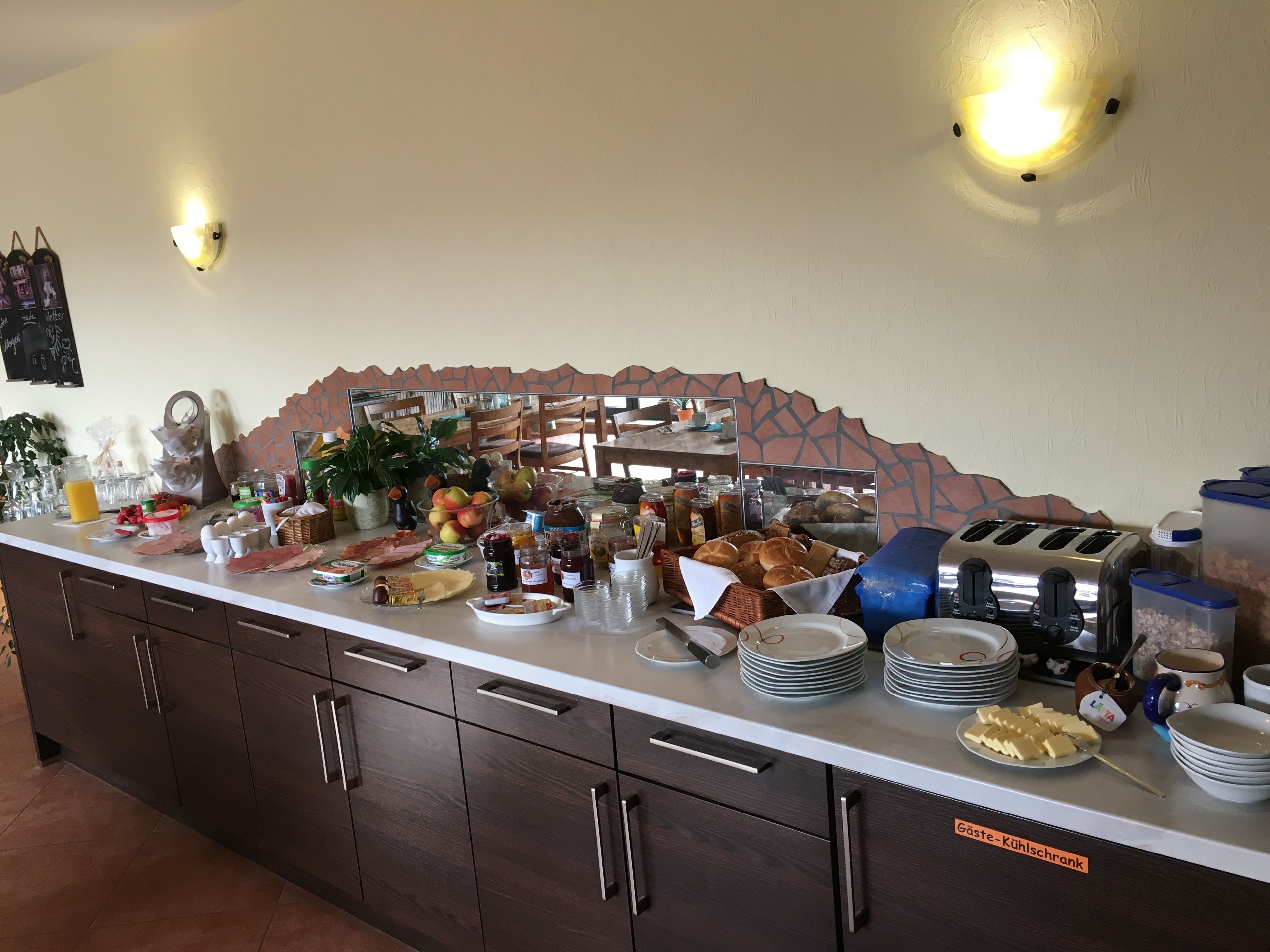 A buffet setup with various food items, a toaster, and a coffee machine.