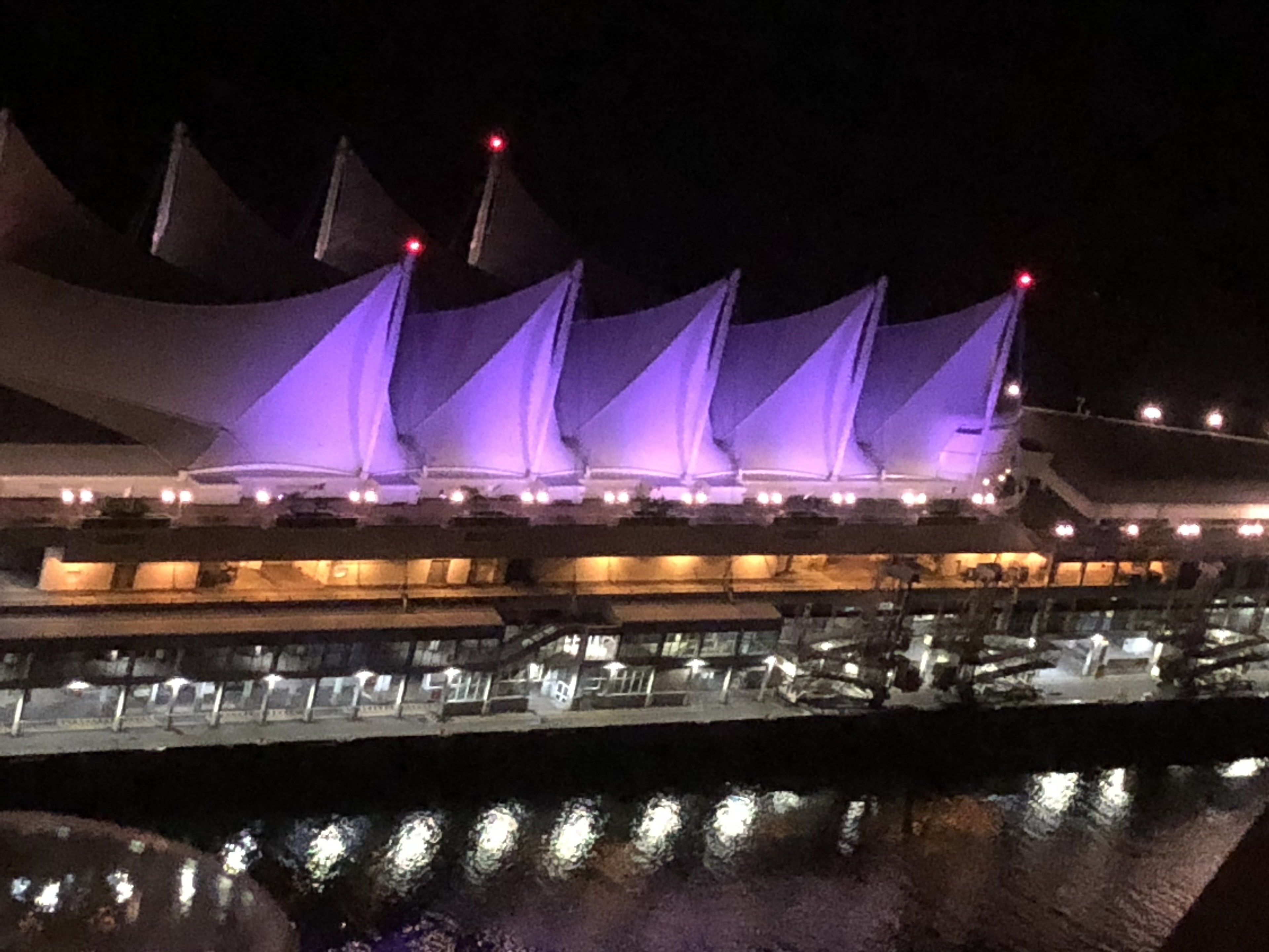 A building with multiple levels and a series of lights along the upper edge.