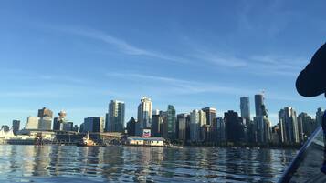 A city skyline with high-rise buildings and a body of water reflecting the buildings.