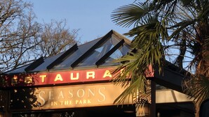 Une enseigne de restaurant portant le nom « SEASON’S IN THE PARK ».