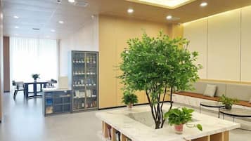 Un interior moderno con una mesa de mármol, plantas en macetas y una zona de estar.