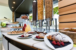 A breakfast buffet with various pastries, fruits, and a coffee dispenser. - Hotel Club Astor (Ugento)