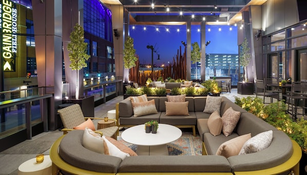 A modern lounge area with a sectional sofa, round coffee table, and various seating options.