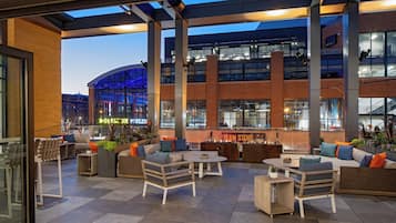 An outdoor seating area with modern furniture, a Team Store, and a view of the building's interior.