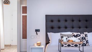 A modern bedroom with a tufted headboard, a bedside table with a lamp, and a tray with breakfast items.