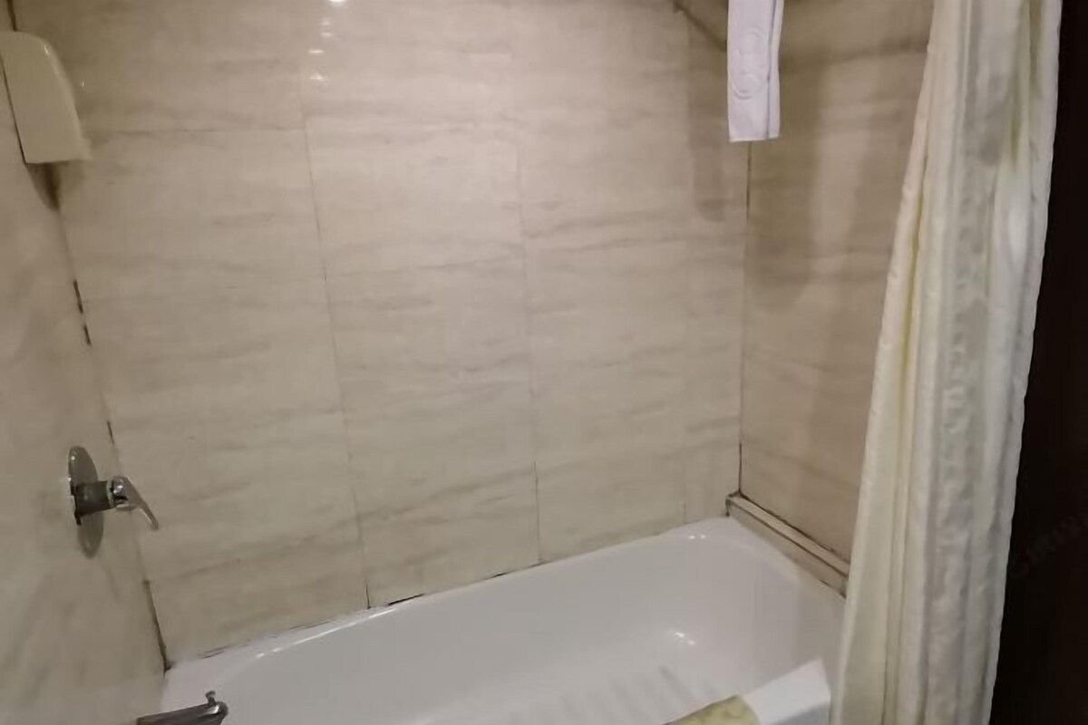 A bathroom with a bathtub, a towel rack, and a shower curtain.
