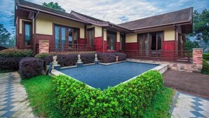 A two-story house with a swimming pool, surrounded by well-maintained hedges and a stone pathway. - Ningguo Wooden Villa of the World (Ningguo)