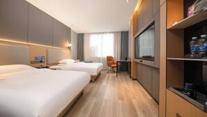 Une chambre d’hôtel avec deux lits, un bureau et une chaise.