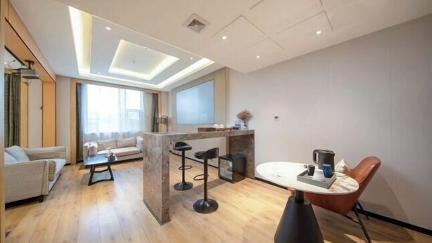 Un salon moderne comprenant un canapé, une table basse et un coin repas avec une table et des chaises.