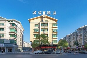 A multi-story hotel with a prominent entrance, several floors, and a clear sky. - Junlin Four Seasons Hotel (ZHEJIANG)