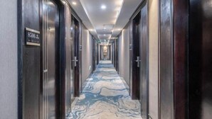 A hotel corridor with a marble floor, dark wooden doors, and a sign indicating room number 8506. - Junlin Four Seasons Hotel (ZHEJIANG)
