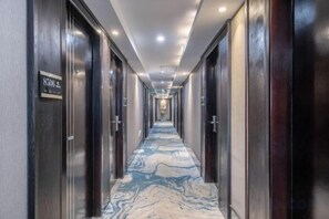 A hotel corridor with dark wooden doors, a marble-patterned floor, and a sign indicating room number 8506. - Junlin Four Seasons Hotel (ZHEJIANG)