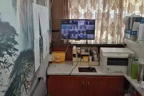 A small office space with a computer monitor, printer, and various office supplies on a desk. - Junlin Four Seasons Hotel (ZHEJIANG)