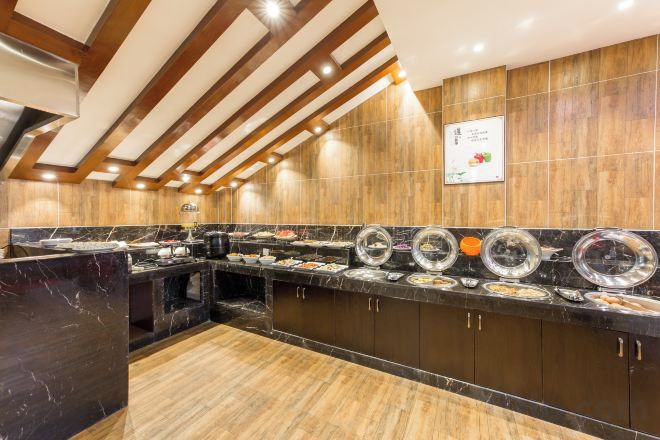 Una cocina de hotel con encimera de mármol, techo de madera y un letrero que indica un restaurante.