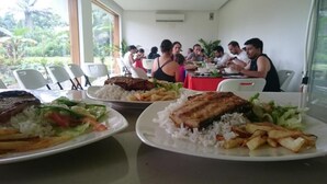 A dining area with tables set for meals, including plates of food and a group of people dining. - Hosteria Piedra De Vapor (Puerto Quito)