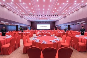 A conference room with round tables, red chairs, and a presentation screen. - ZheShang ShiMao Yulong Hotel (Haining)