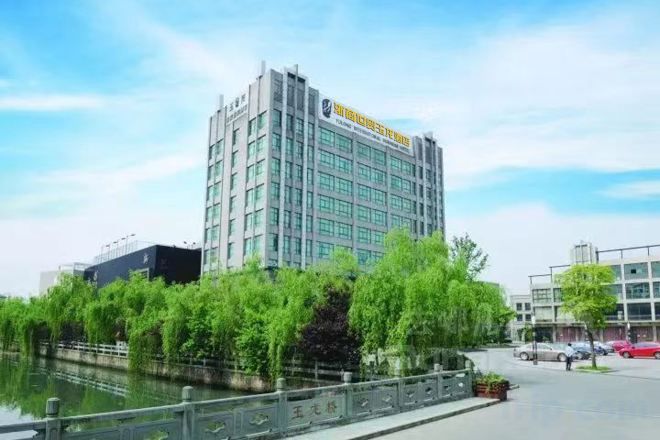 Un hotel moderno con una estructura de varios pisos, un río al frente y un paseo peatonal.