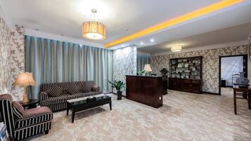 A hotel lobby with a sofa, coffee table, and a reception desk.