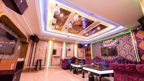 Un interior moderno con una zona de bar, asientos y una televisión.
