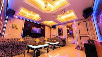 A luxurious living room with a flat-screen TV, plush sofas, and a coffee table.