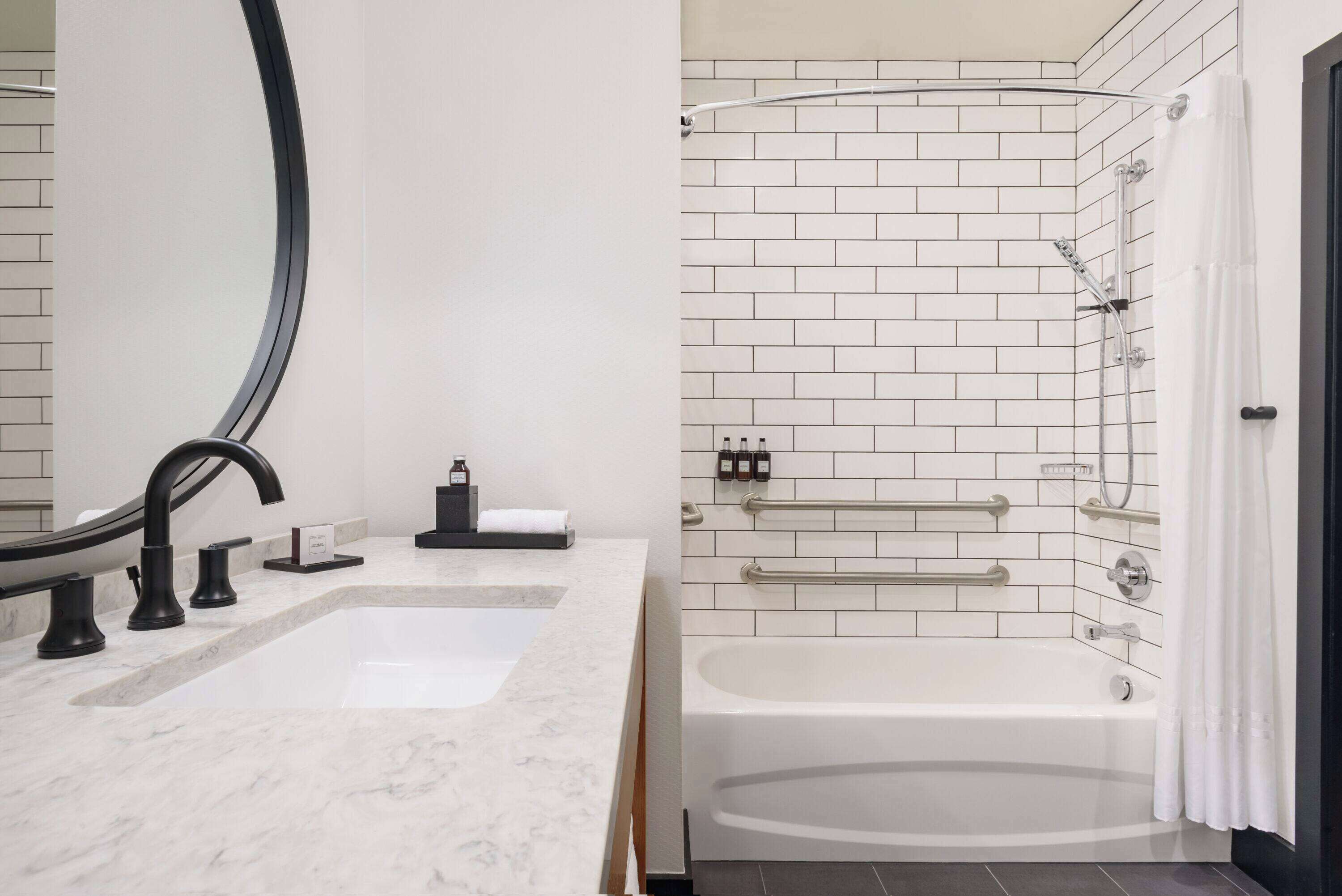 A modern bathroom with a large sink, a bathtub, and a shower area.