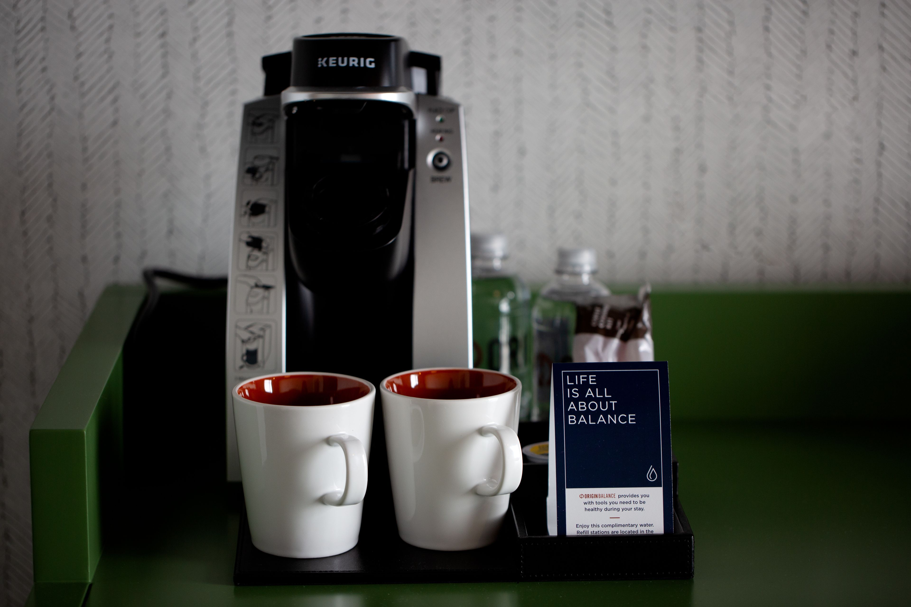 Una cafetera, dos tazas y un letrero sobre equilibrio.