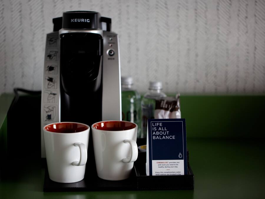 Una cafetera, dos tazas y un letrero sobre equilibrio.