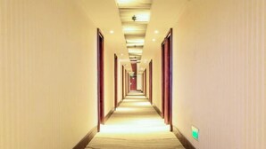 A long, narrow hotel corridor with a carpeted floor and wooden doors on both sides. - Jinchang Hotel (Shaoxing)