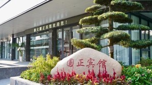 A building entrance with a stone plaque and a well-maintained garden. - Yuanzheng Hotels (Hangzhou)
