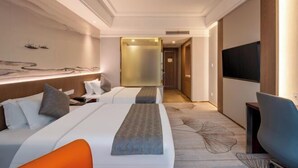 A modern hotel room with a bed, bedside table, TV, and a view of the hallway. - Hailiang Business Hotel (Zhuji)