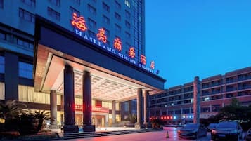 A hotel with a large entrance, multiple floors, and a prominent sign.