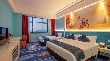 A hotel room with two beds, a TV, a desk, and a large window.