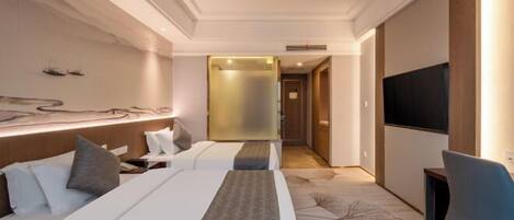A modern hotel room with a large bed, a desk, a television, and a decorative wall.
